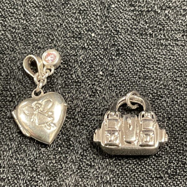 Silver charms including a heart locket and handbag design.