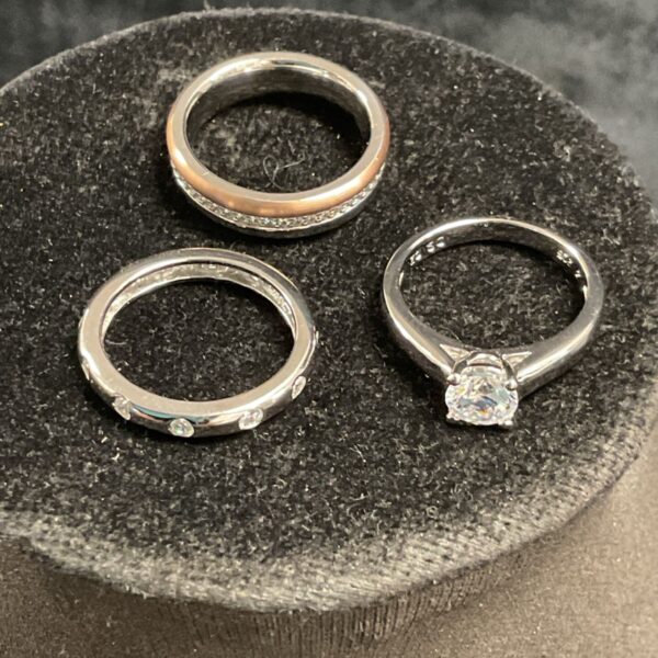 Silver and steel rings set with CZ stones, size M.