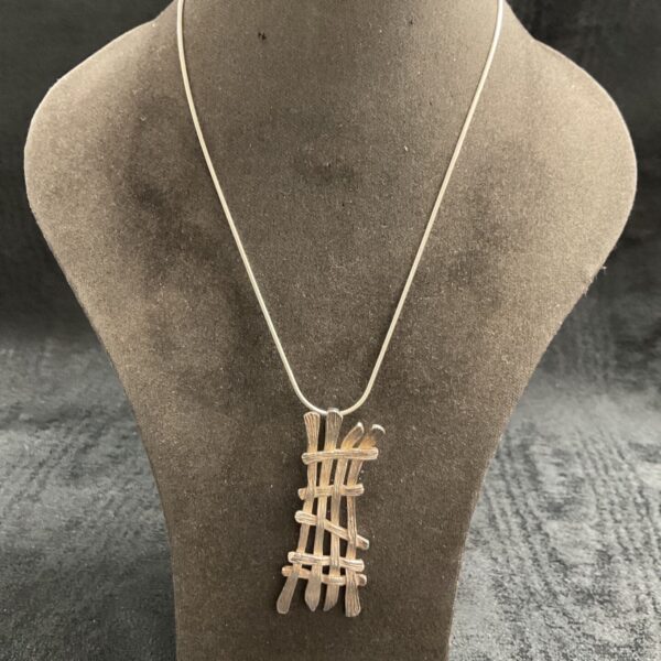 Close-up of silver modernist twig pendant necklace.