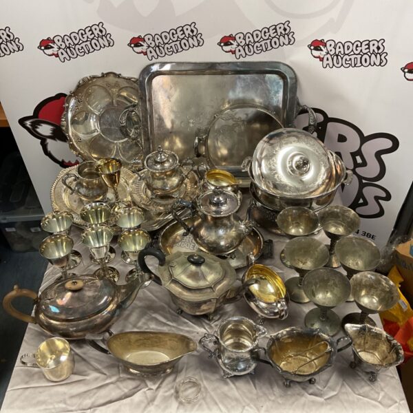 Vintage silver plate collection featuring trays, teapots, and goblets.
