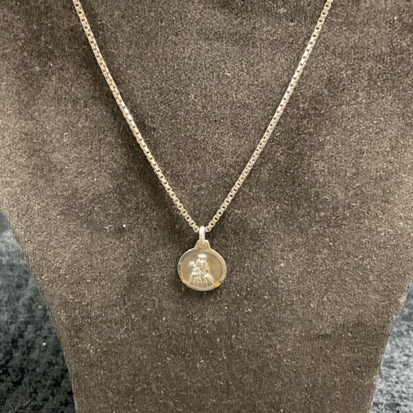 Vintage silver religious pendant necklace with devotional imagery.