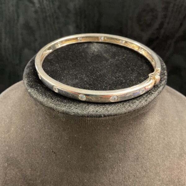 Elegant silver hinged bracelet with white stones.