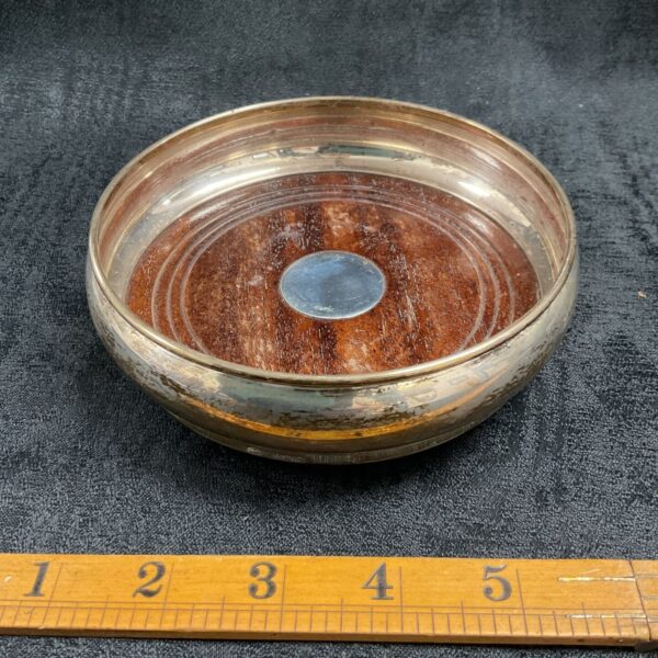 Antique silver wine bottle coaster with hallmarked silver detail.
