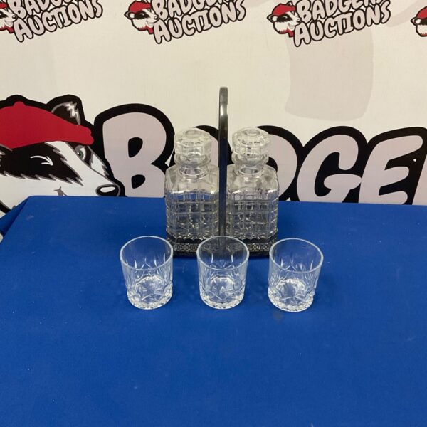 Vintage silverplate decanter set with glasses on display.
