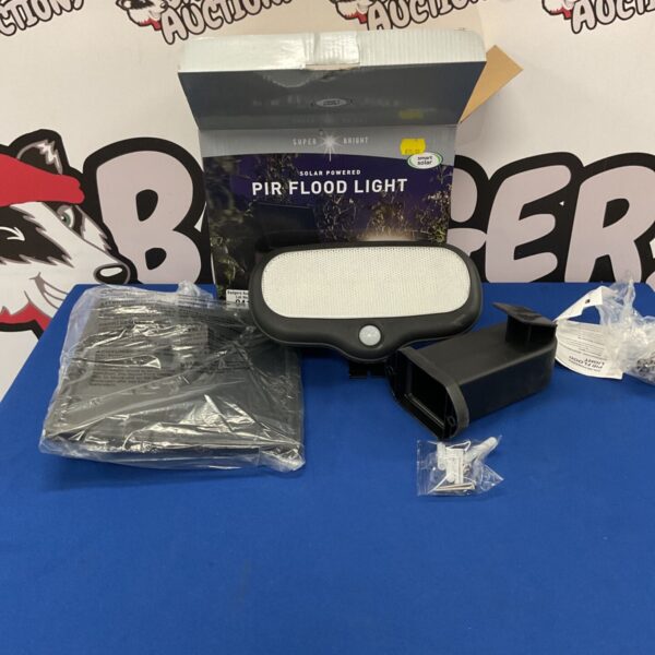 Front view of a solar powered PIR flood light in its packaging.