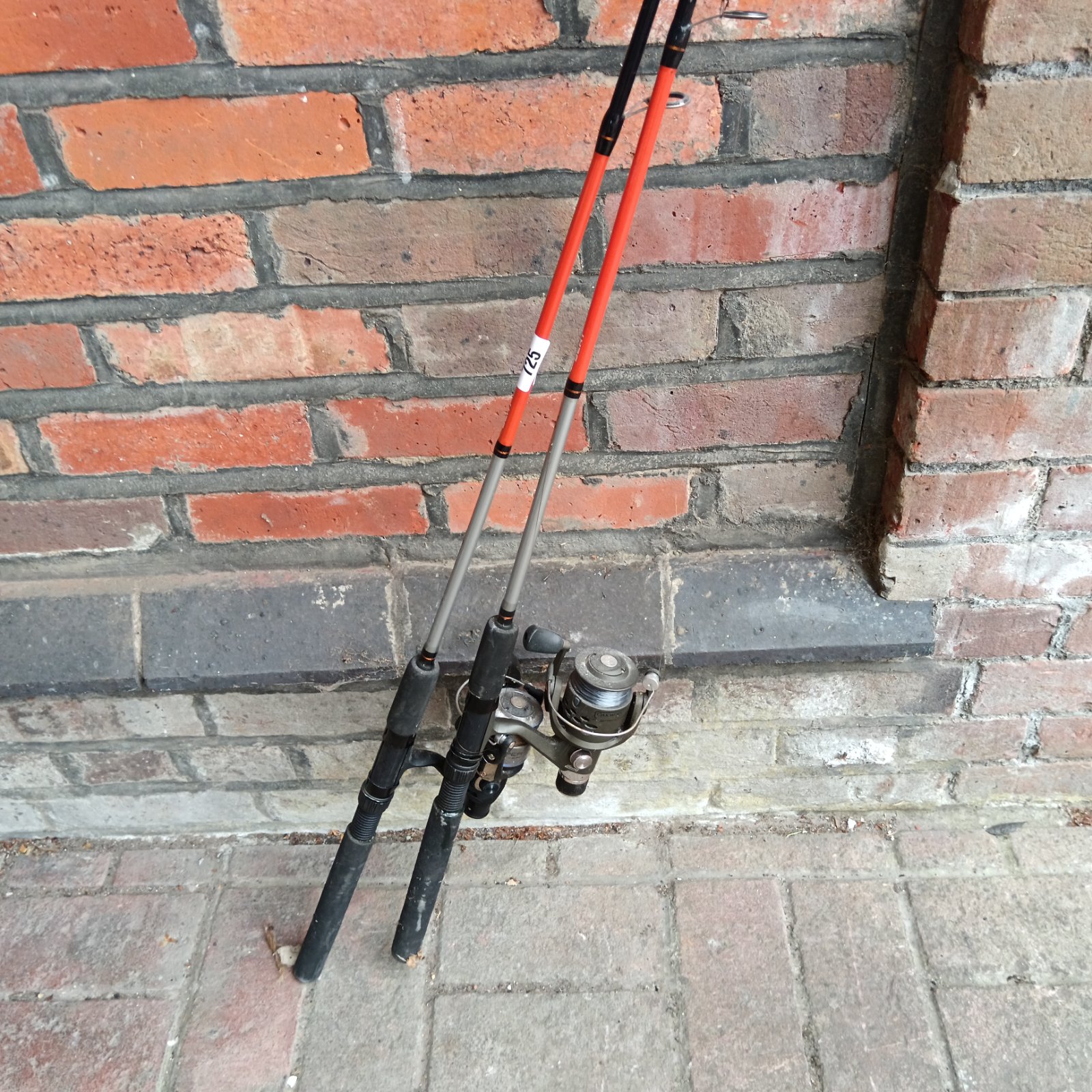 Pair of spinning fishing rods with reels, one damaged.