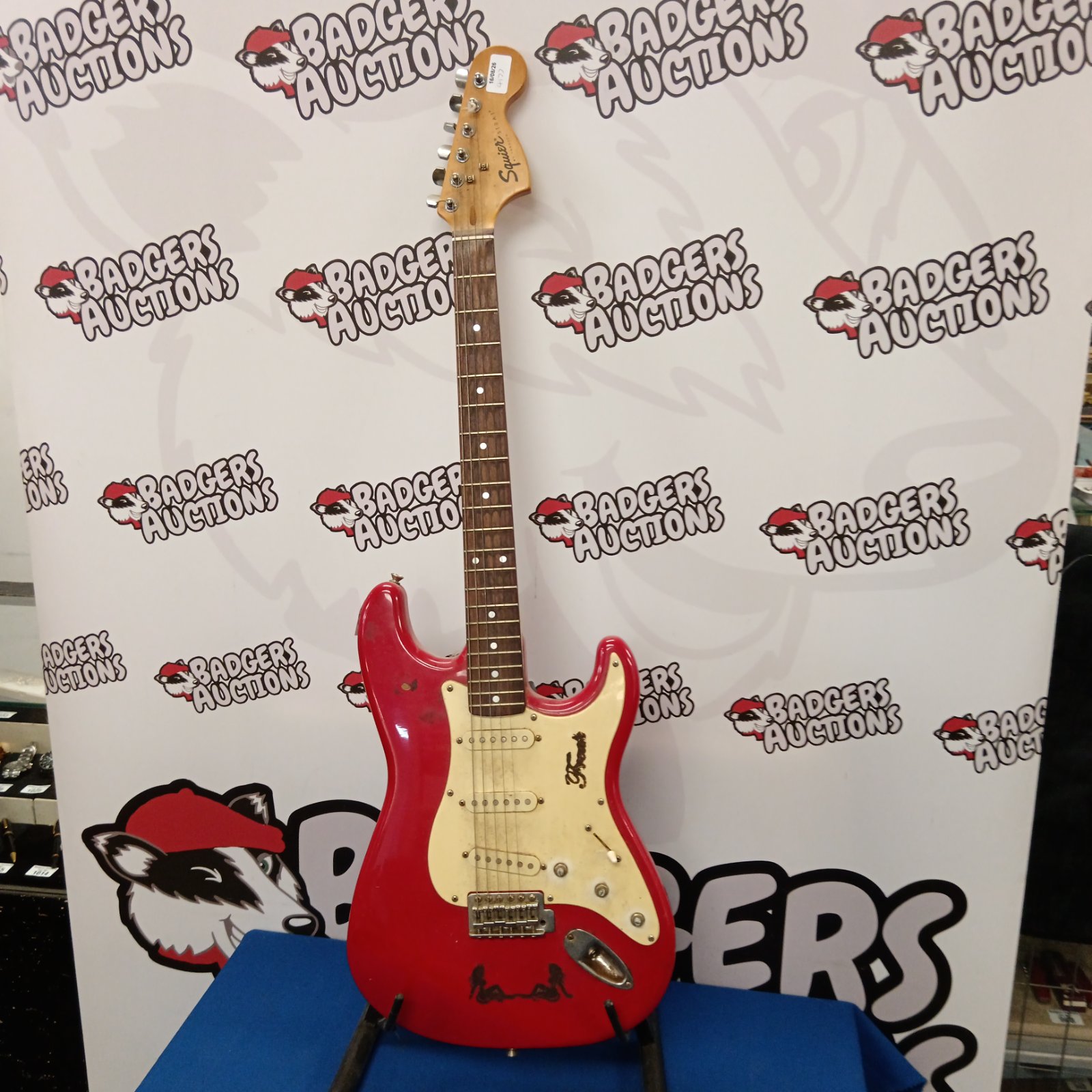 Red Squire Stratocaster electric guitar, vintage style instrument.