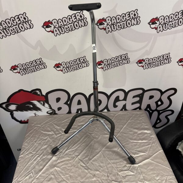 Collapsible Stagg guitar stand for secure instrument storage.