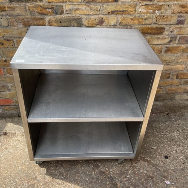 Stainless steel machine table with three compartments on wheels.