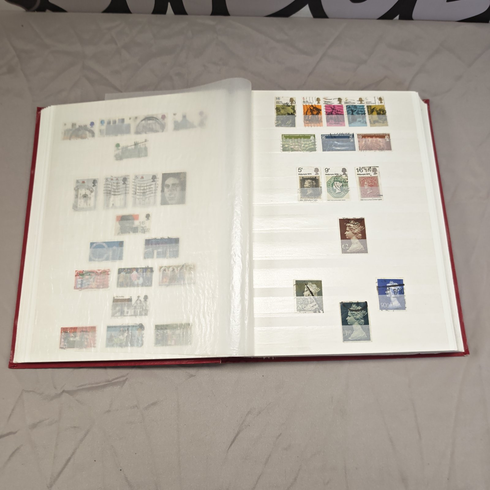 Open stamp album displaying a collection of British stamps.