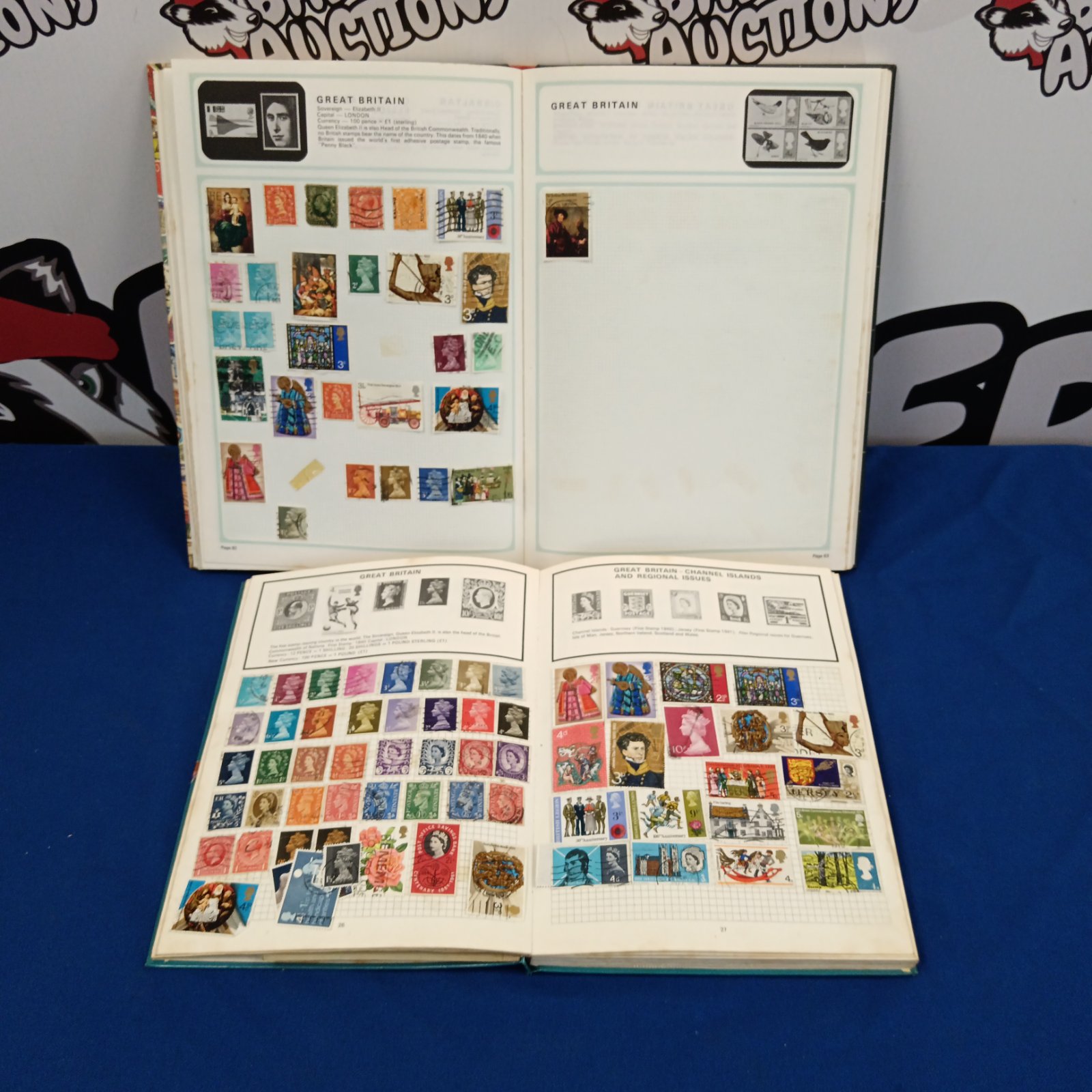 Vintage stamp albums showing Great Britain and Channel Islands stamps.