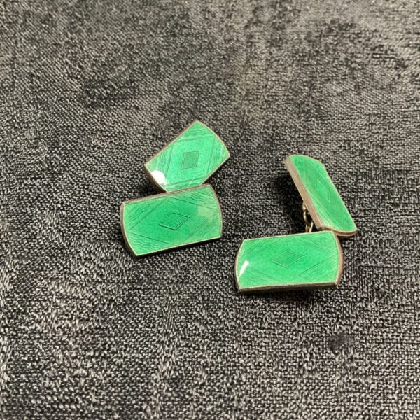 Vintage sterling silver cufflinks with green enamel detailing.