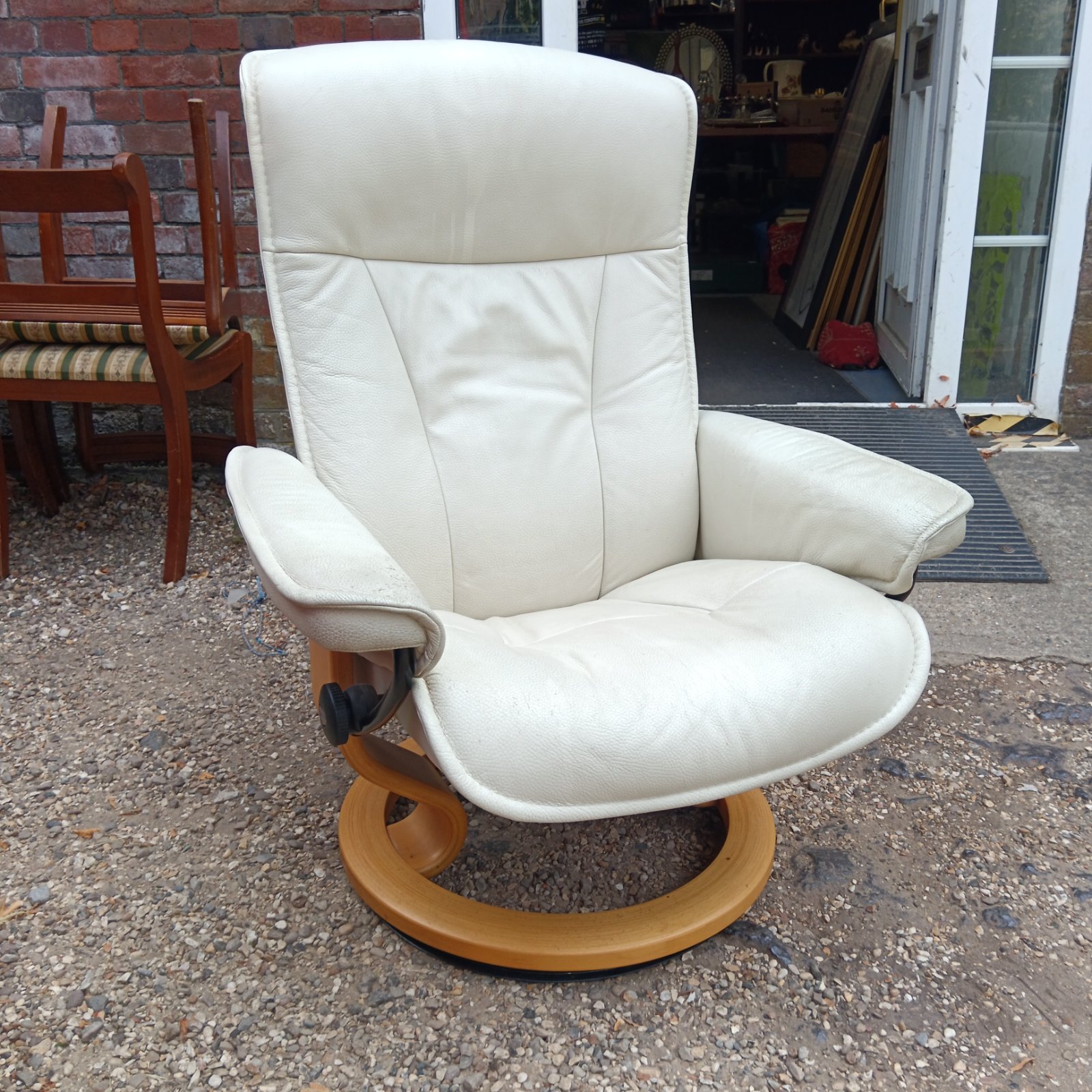 Cream leather Stressless reclining armchair in a home setting.
