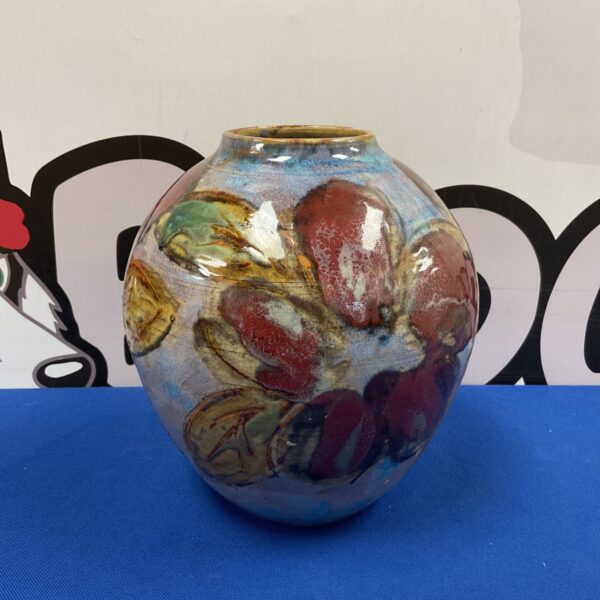 Colorful studio pottery vase with fruit design.