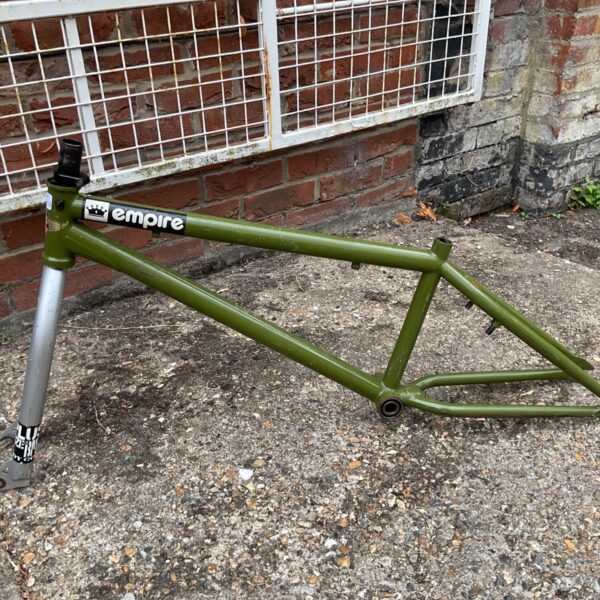Olive green Sunday BMX frame and forks with front wheel attached.