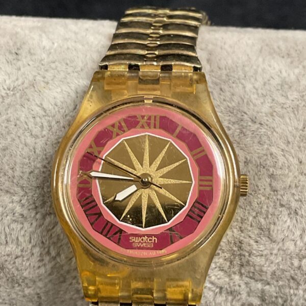 Vintage Swatch wristwatch with gold dial and Roman numerals.