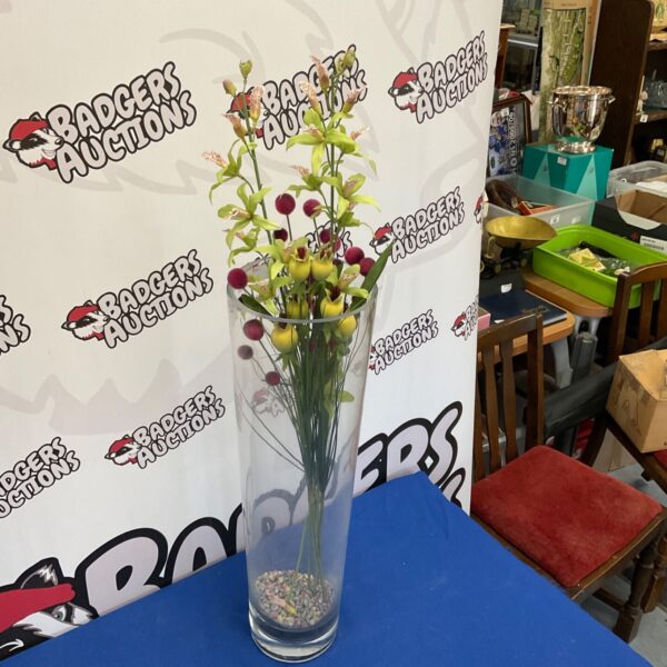 Tall glass vase displaying vibrant artificial flowers for home decor.