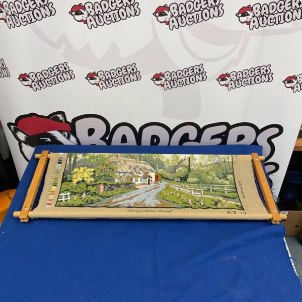 Vintage tapestry frame with a detailed countryside landscape scene.