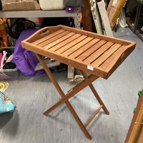 Teak folding table with slatted top and X-frame base.