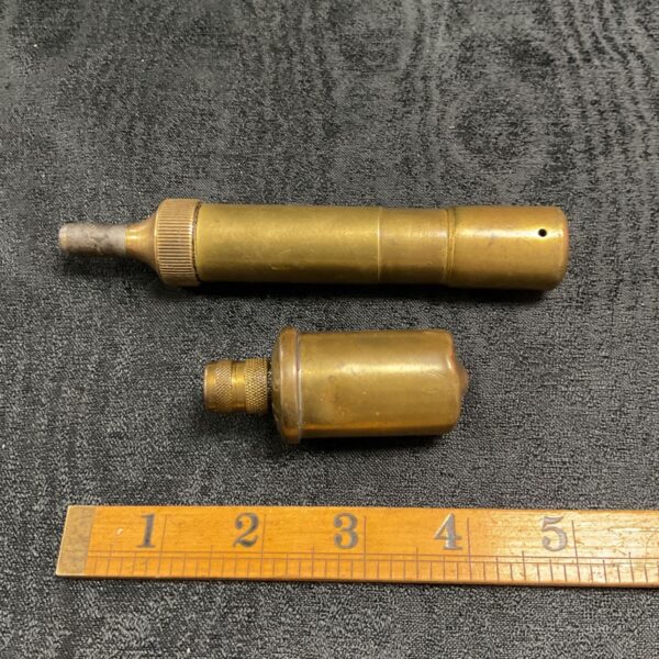 Pair of vintage brass Tecalemit grease guns on ruler.