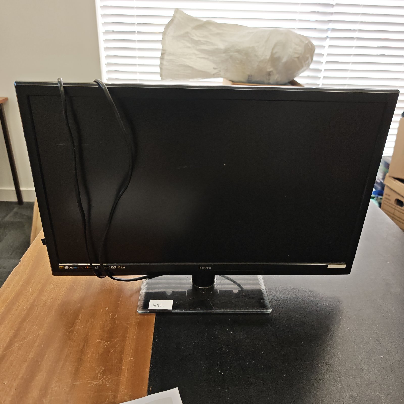 Front view of a Technika DVD television on a wooden surface.