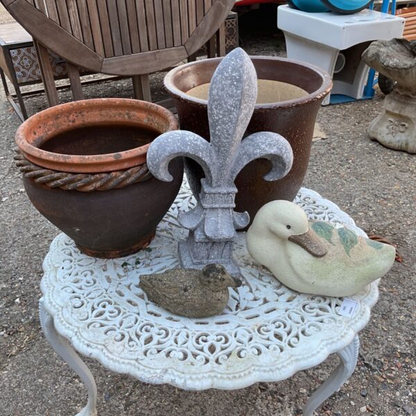 Vintage terracotta garden pots and ornaments in a garden setting.