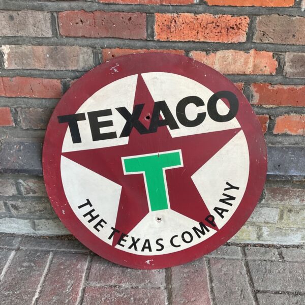 Vintage Texaco sign against a red brick wall.