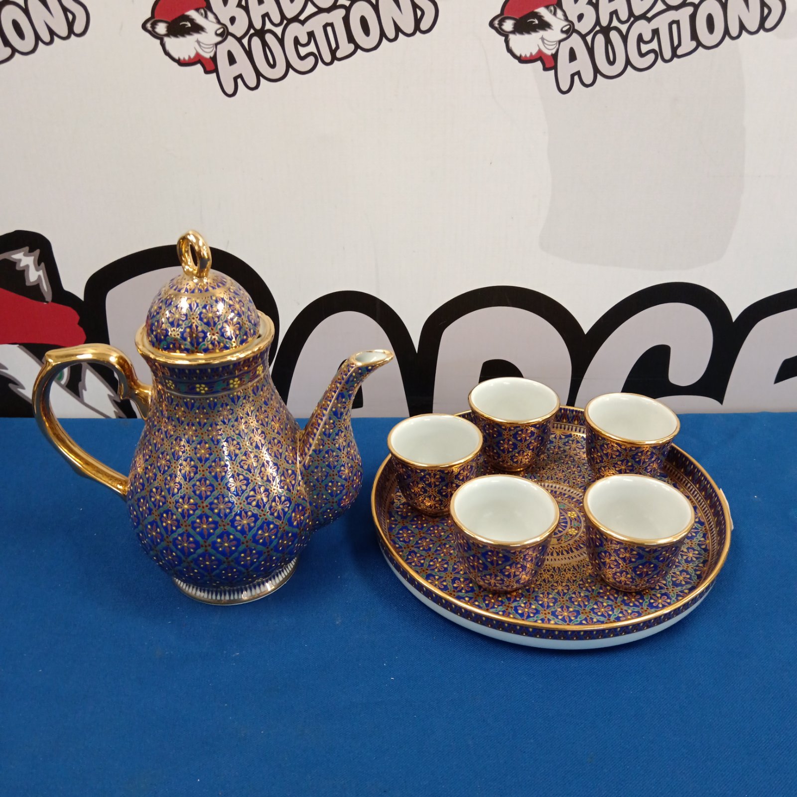 Vintage Thai hand-painted coffee set with gilt details on a blue tray.