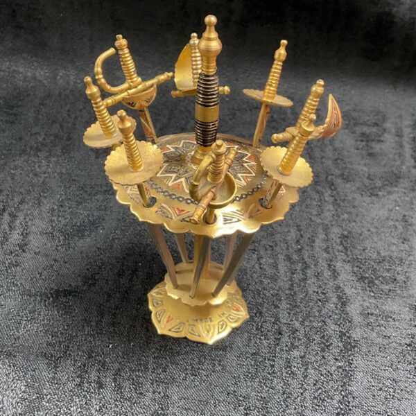 Vintage Toledo cocktail swords on a decorative stand.