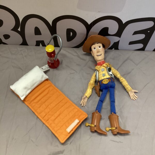 Vintage Toy Story Woody doll with lantern and sleeping mat.