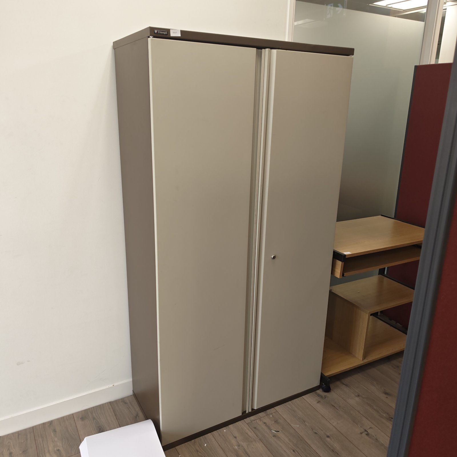 Grey metal Triumph filing cabinet for office storage.