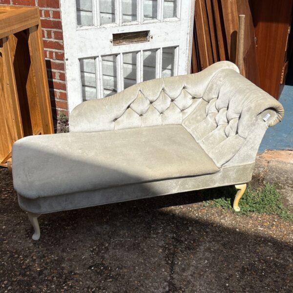 Light-colored velvet Chesterfield chaise longue with button tufting.