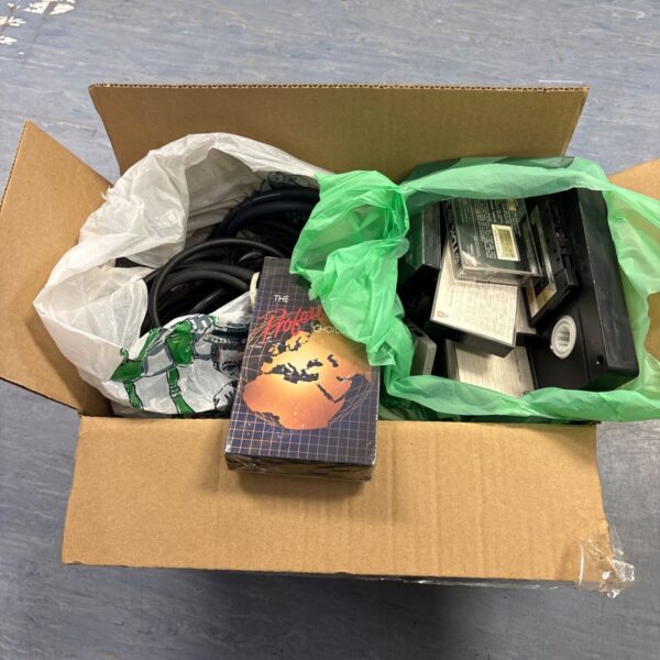 Mixed lot of VHS tapes, cassette tapes, and cabling.