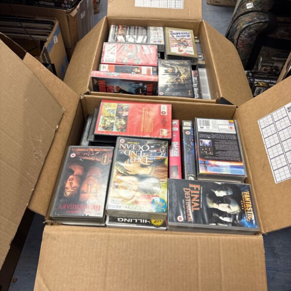 Lot of VHS movie tapes in cardboard boxes.