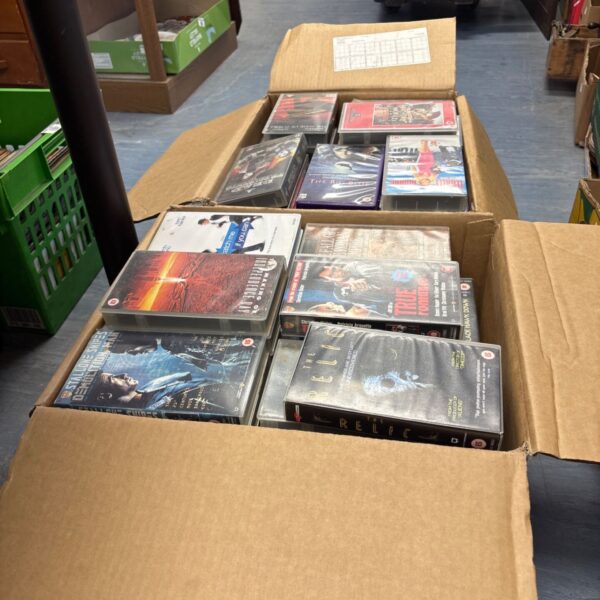 Two boxes filled with a collection of VHS movie tapes.