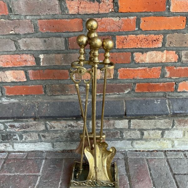 Ornate Victorian brass fireplace companion set with four tools.
