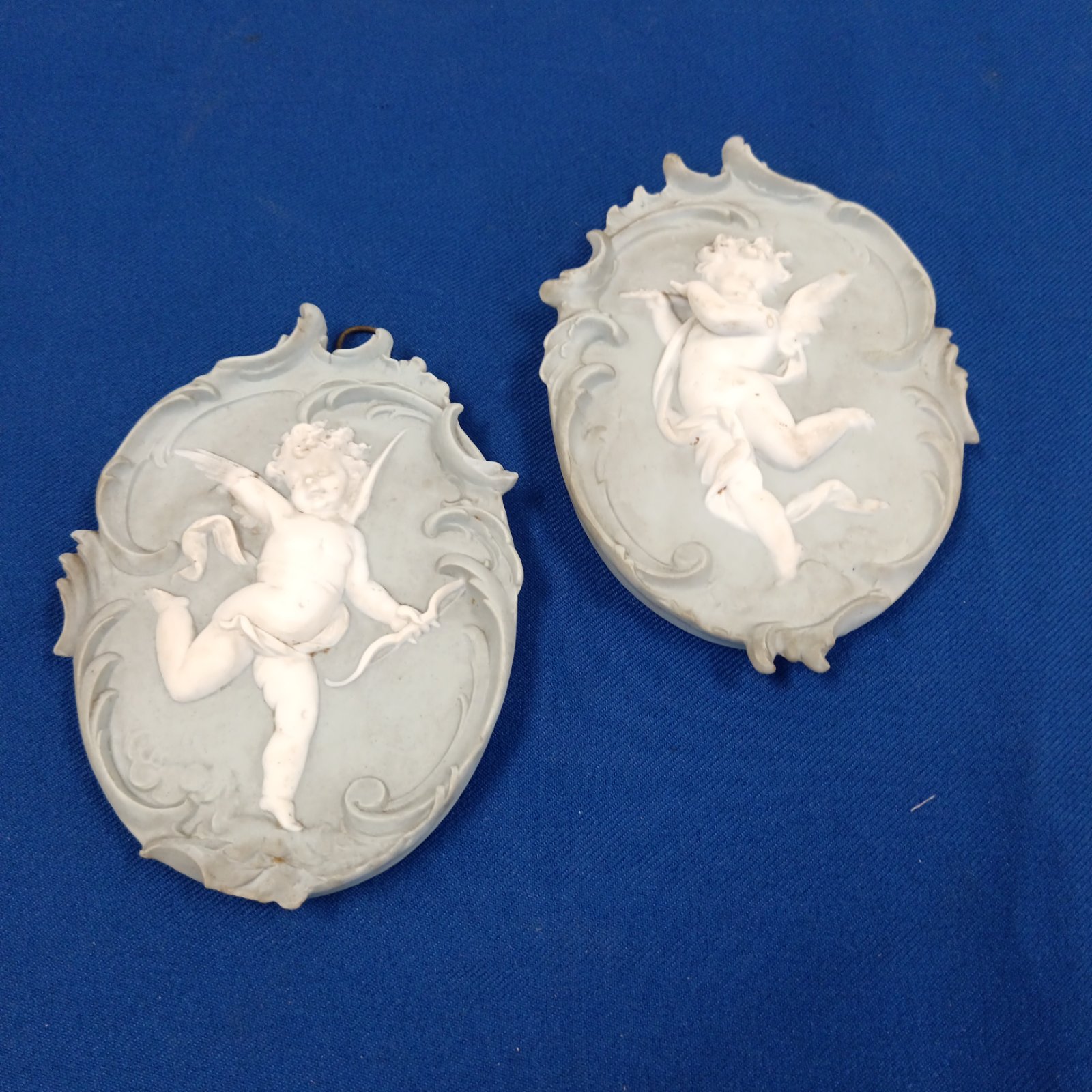 Victorian cherub wall plaque with a cherub holding a bow and arrow.