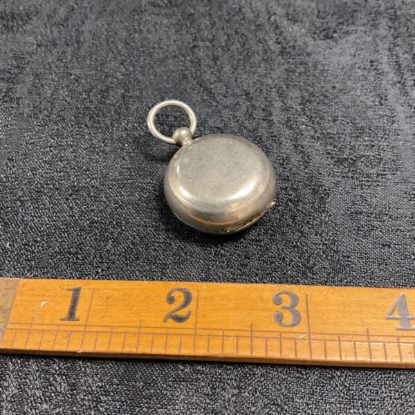 Antique Victorian silver sovereign case with ruler for scale.