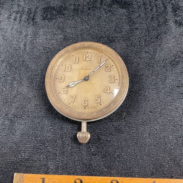 Vintage 8 day travel clock with brass case and clear dial.