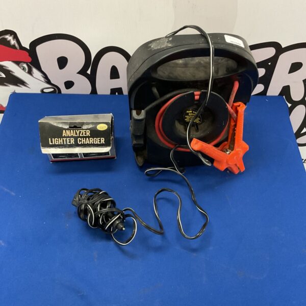 Vintage automotive jump starter with integrated jumper cables.