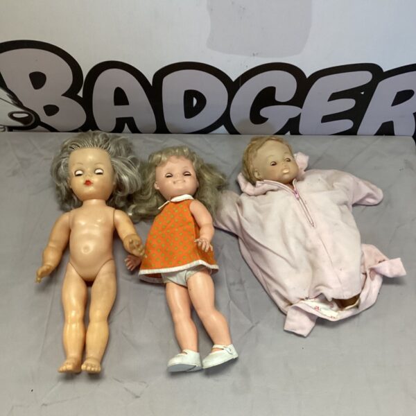 Vintage baby doll lot with patterned and pink outfits.