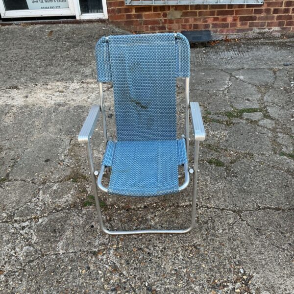 Vintage blue striped deck chair in garden setting.