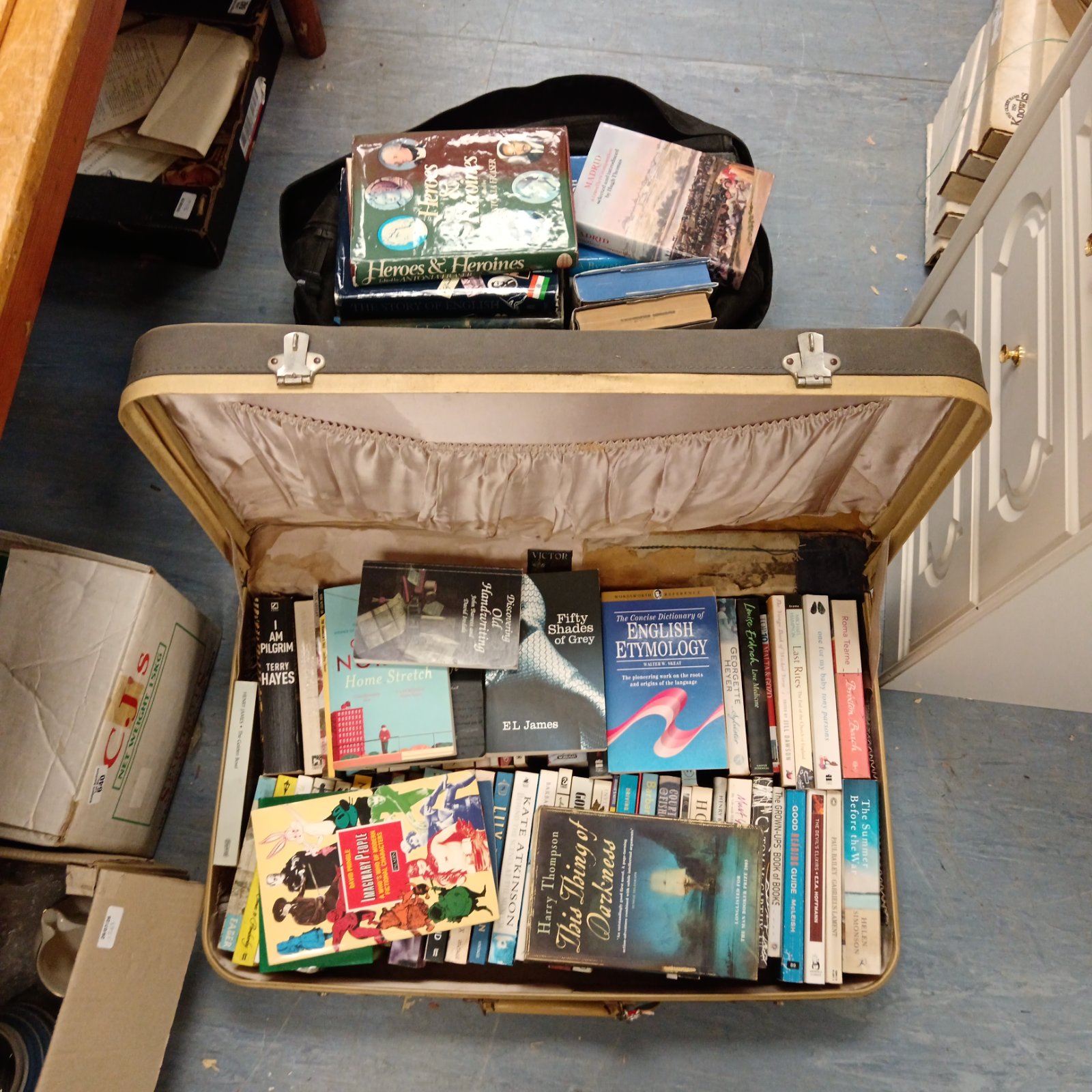 Vintage book lot inside a worn travel case, collectible books.