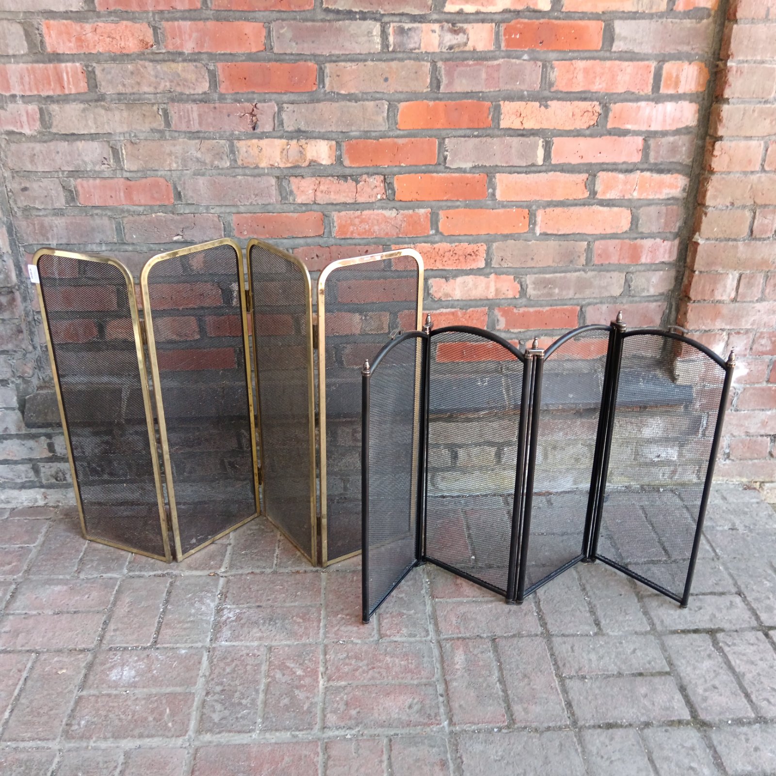 Vintage brass quad-fold fire screens with mesh panels.
