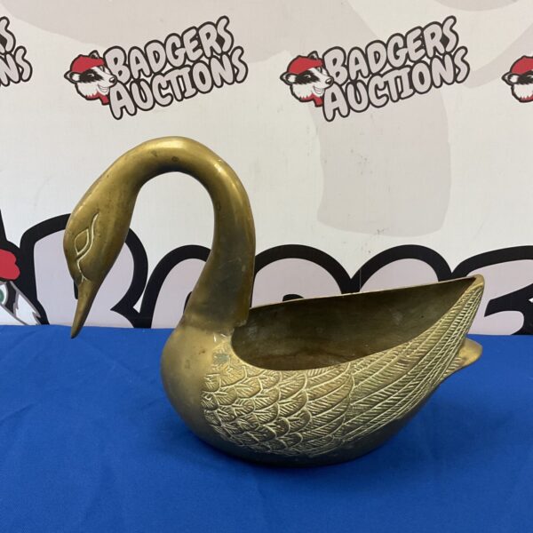 Vintage brass swan plant pot holder with detailed feathering.