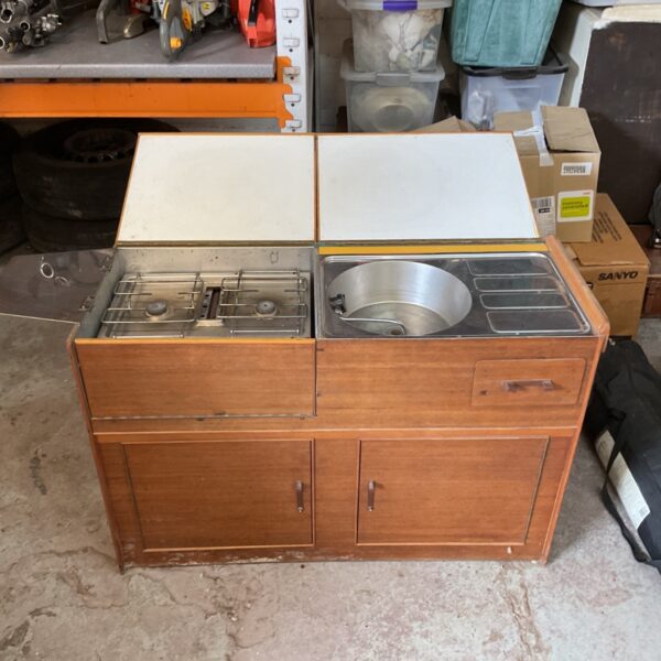 Vintage camping kitchen unit in a garage setting.