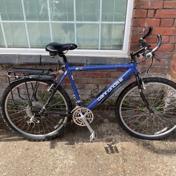 Vintage blue Cannondale SM700 rigid mountain bike with rear rack.