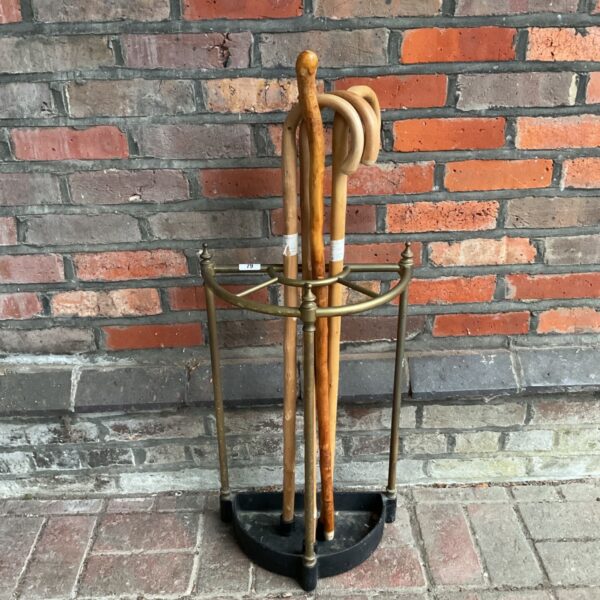 Vintage cast iron and brass umbrella stand with walking sticks.