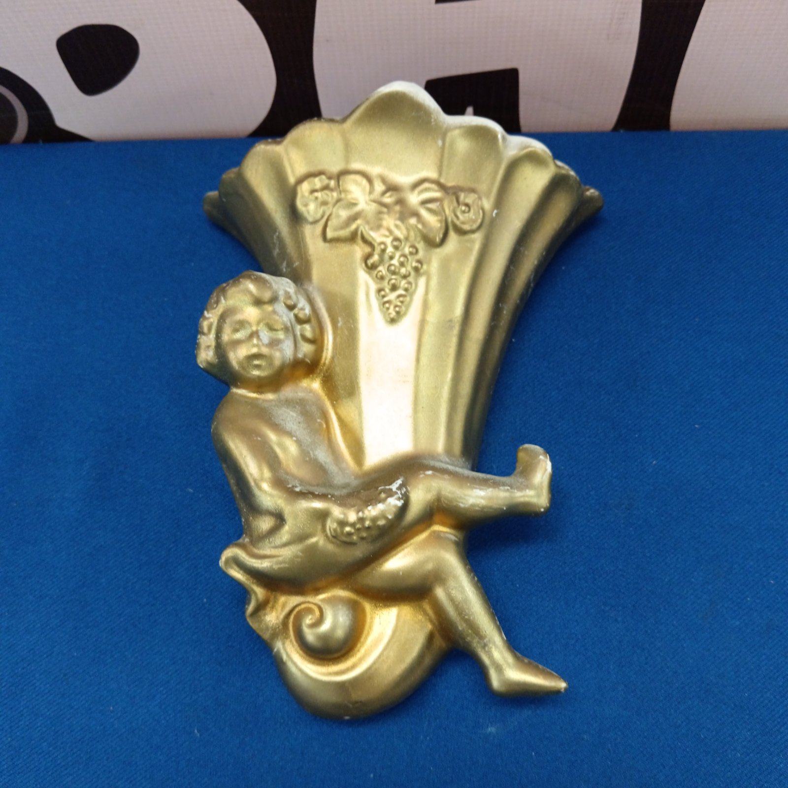 Vintage gilded cherub wall sconce with floral details.