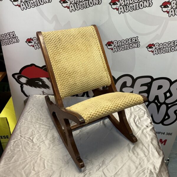 Vintage children’s rocking chair with woven seat and wooden frame.